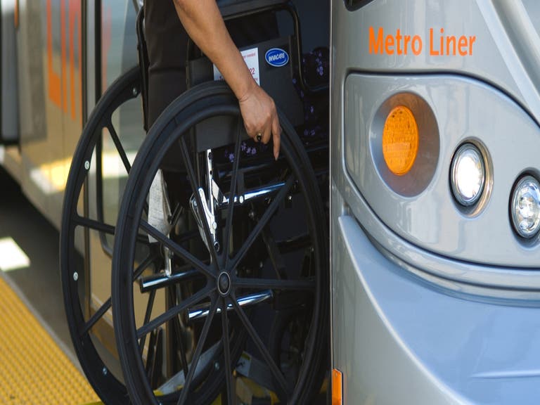 Rider in wheelchair boarding a Metro Orange Line bus